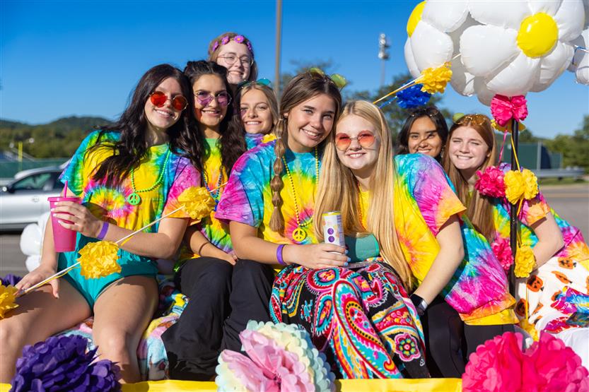 Students ride on a homecoming parade float